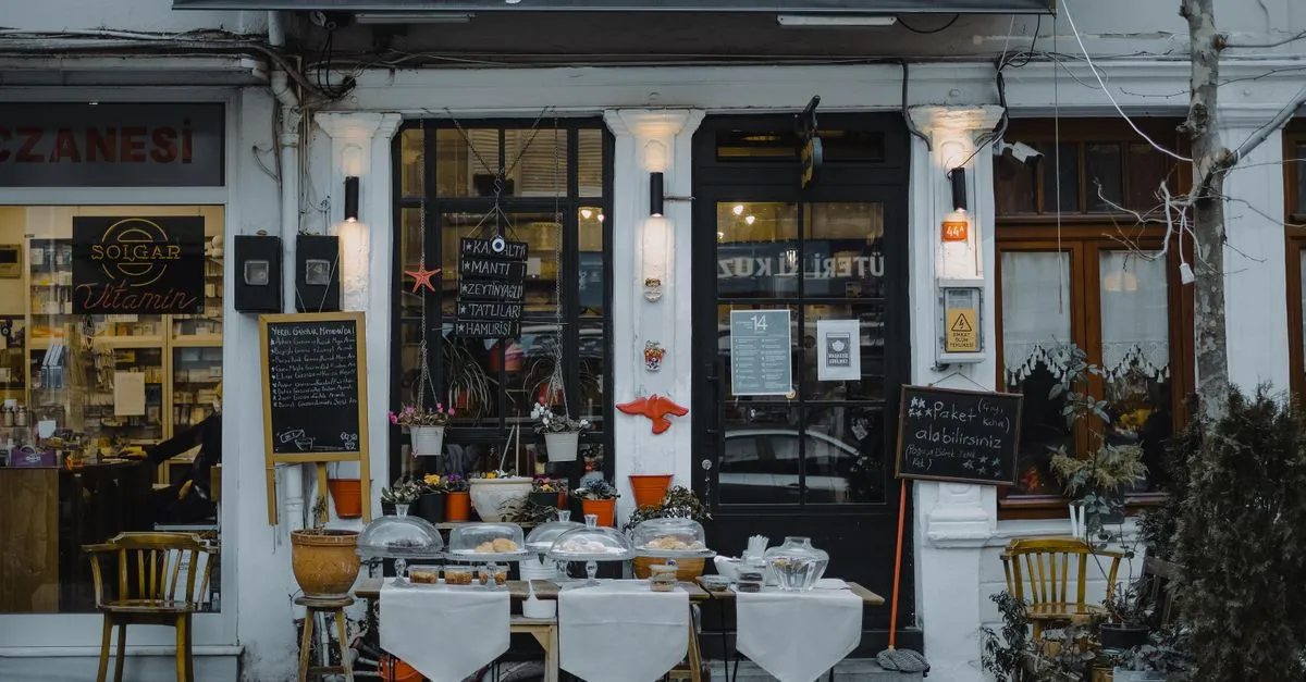 A local café storefront with menu boards and outdoor seating on a neighborhood sidewalk.