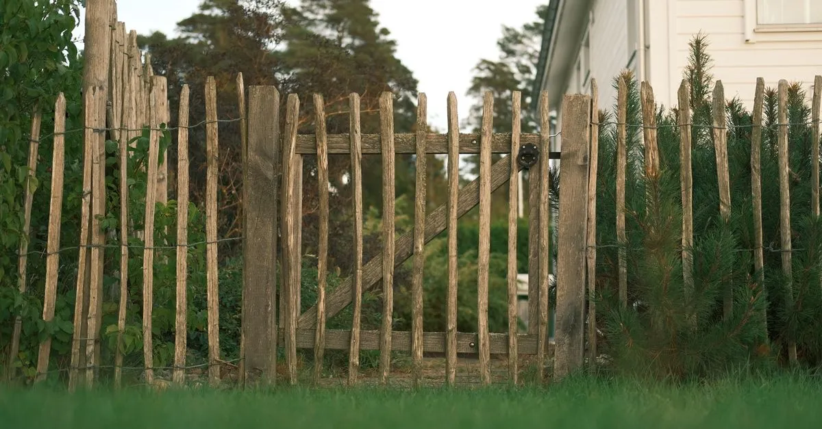 A wooden fence running along the edge of a grassy residential yard, the kind of finished job local searches send to a fencing company.