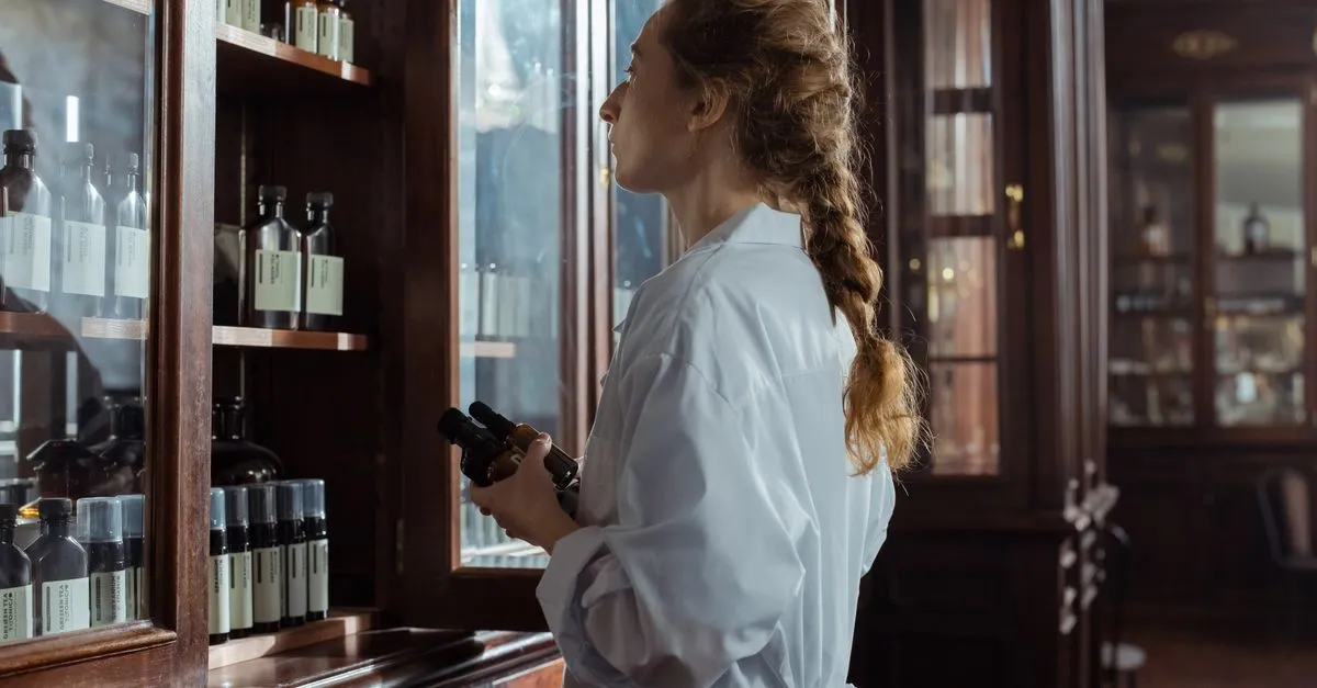 A supplier in a white coat reviewing boxed medical supplies stocked on shelves.