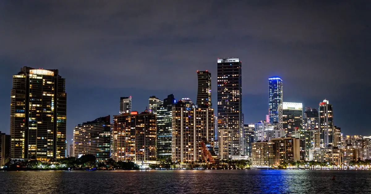 The illuminated Miami skyline at night along Biscayne Bay, the bilingual local market where the map pack is won.