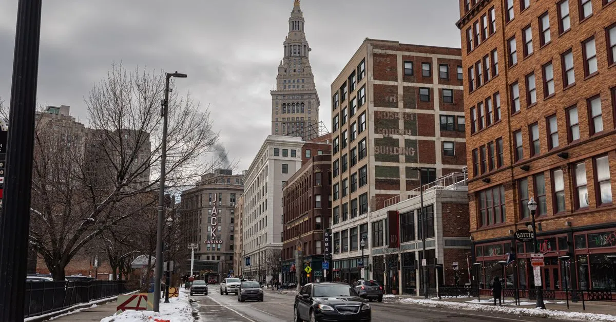 A downtown Cleveland street on an overcast winter day, with Terminal Tower rising above the brick buildings.