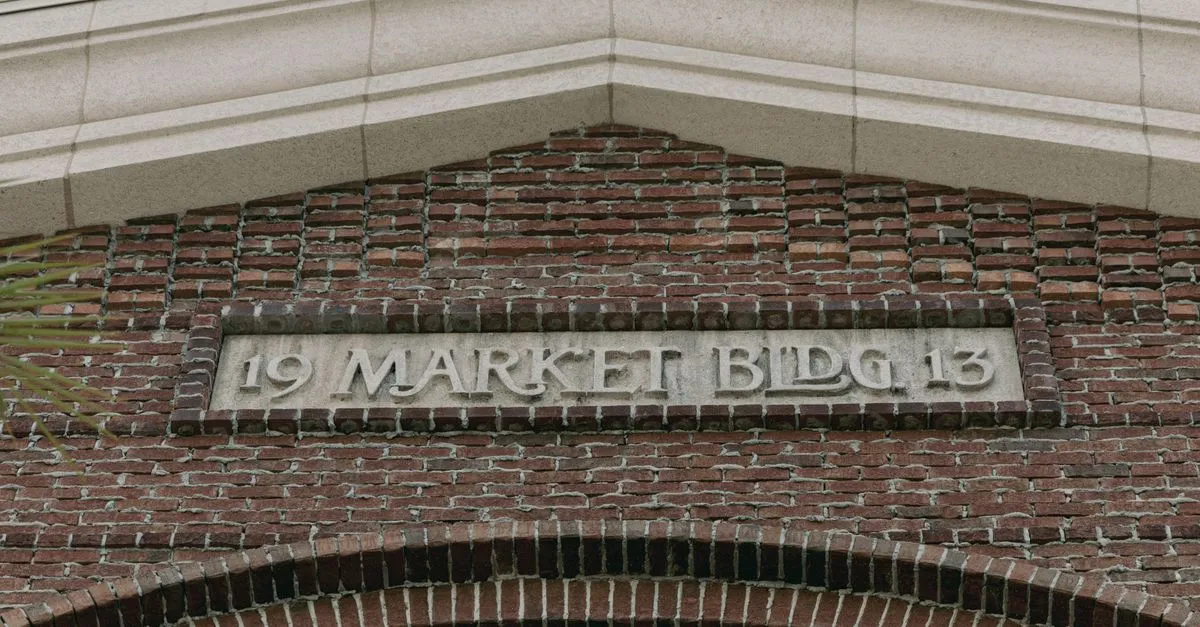 Carved stone lintel reading Market Building set into the red brick facade of a historic warehouse, the kind of building that lines Omaha's Old Market.
