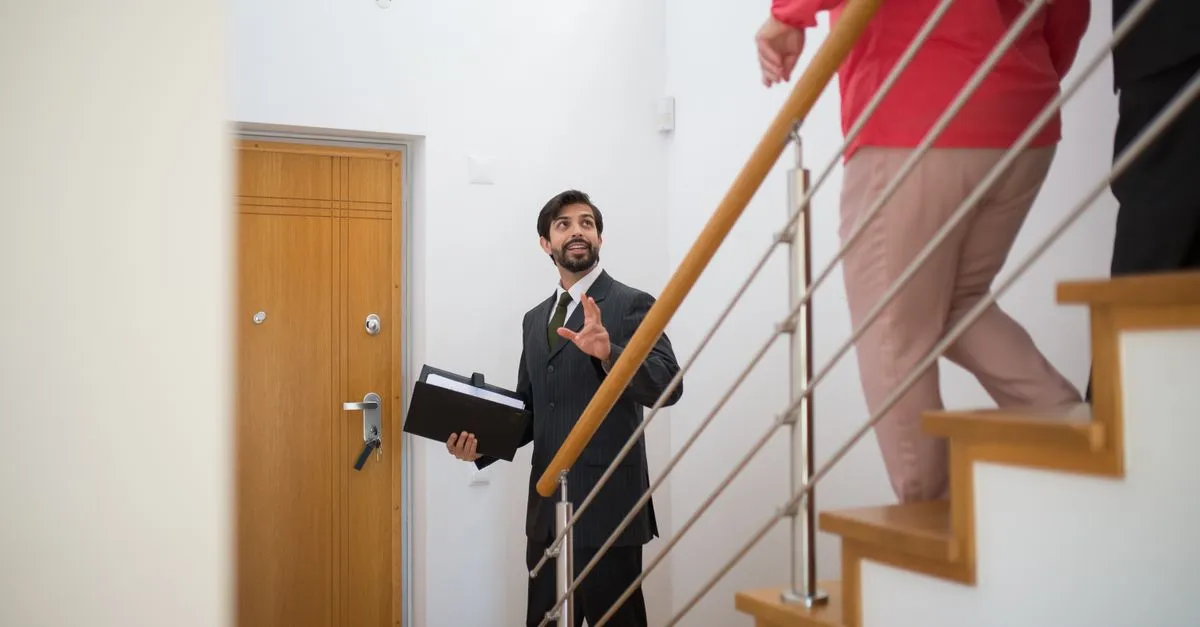 A real estate agent showing buyers a modern home, the kind of agent local SEO for real estate helps get found.
