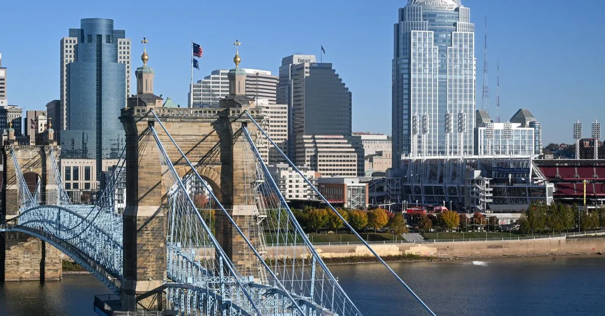 The Cincinnati skyline behind the historic Roebling Suspension Bridge and the Ohio River, where local businesses compete for attention online.