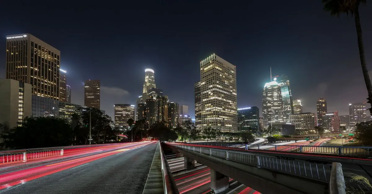 The Downtown Los Angeles skyline lit up at night, the sprawling car-centric metro where the local map pack is won.