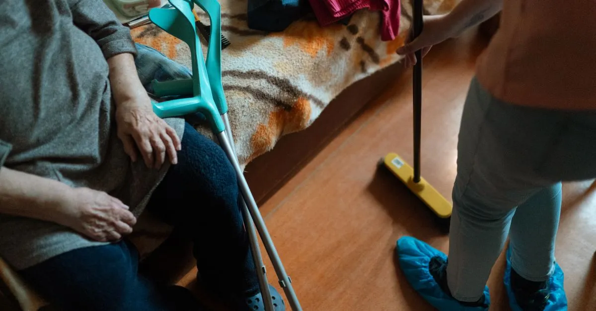 A home care caregiver helps an elderly woman with housekeeping in her own home, the kind of in-home senior care families search for.