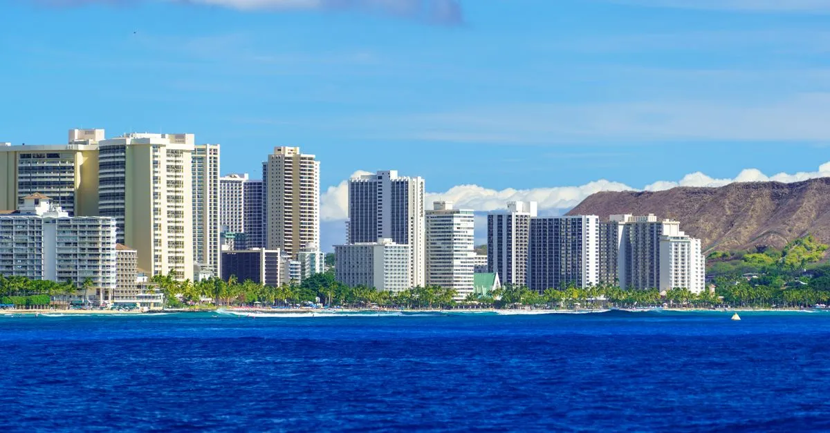 The Waikiki high-rise skyline along the water with the Diamond Head crater rising on the right in Honolulu, Hawaii.