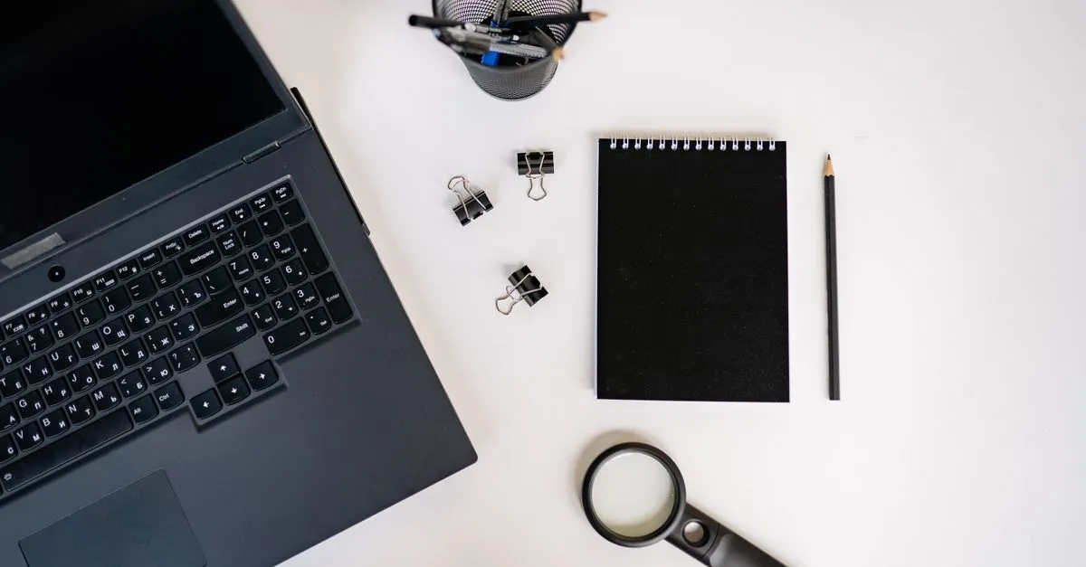 A laptop and notepad on a desk, set up to run a website audit.