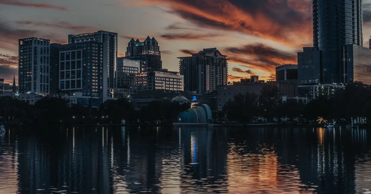 The downtown Orlando skyline at dusk reflected across Lake Eola, the local market where the map pack is won.