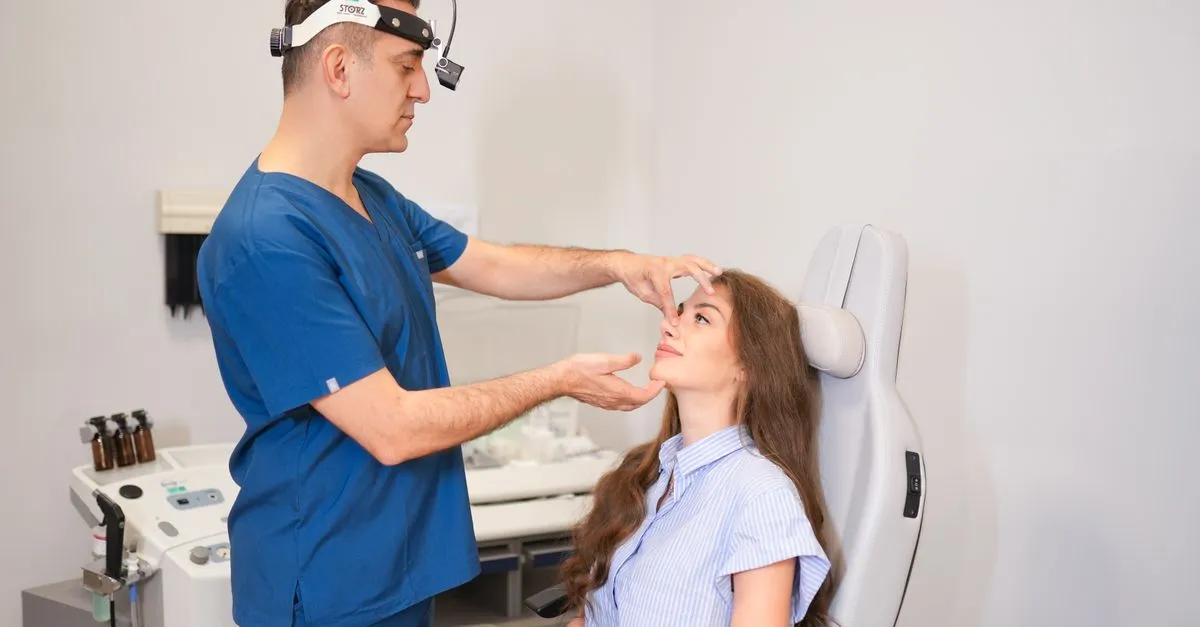 A plastic surgeon examining a patient's nose during a rhinoplasty consultation, the kind of practice local SEO for plastic surgeons helps patients find.