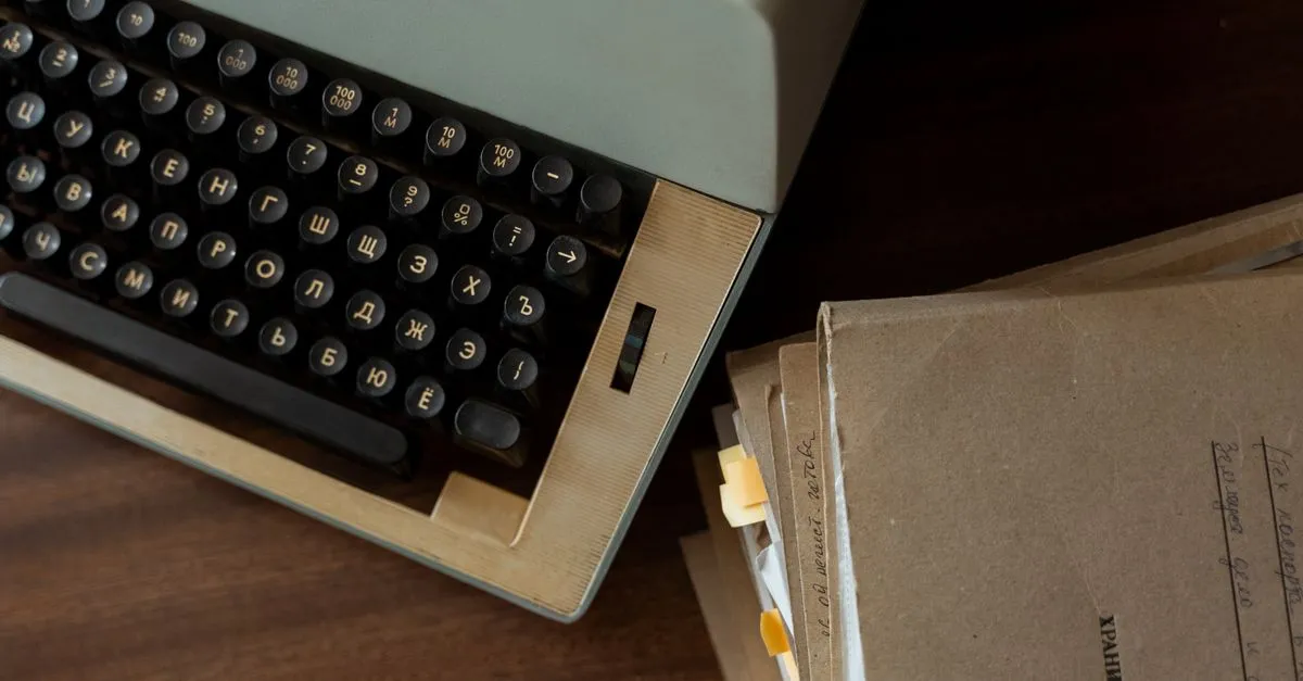 A classic vintage typewriter alongside stacked brown paper documents on a wooden desk.