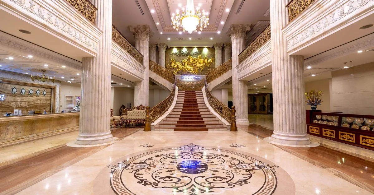 Marble foyer of a luxury hotel with a grand staircase and chandelier, the kind of property SEO for hotels helps travelers discover in search.
