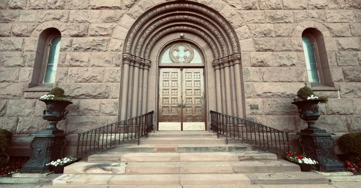 A grand Romanesque stone entrance with an arched doorway and carved stonework, echoing the nineteenth-century architecture Buffalo is known for.