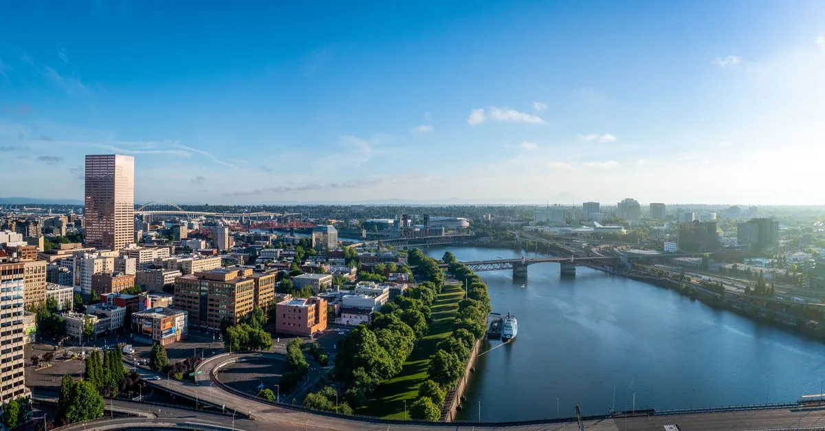 Aerial view of the downtown Portland, Oregon skyline along the Willamette River, with the bridges and Mount Hood on the horizon a Portland SEO strategy has to reach.