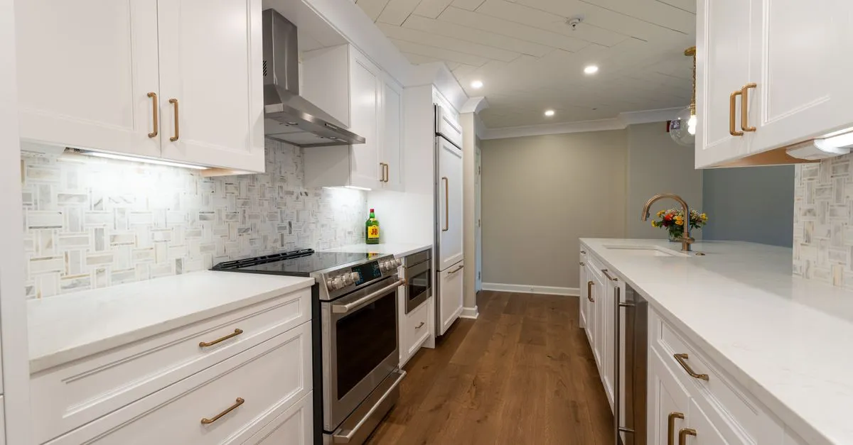 A finished modern white kitchen remodel with new cabinetry and wood floors, the kind of project remodeler SEO helps homeowners find.