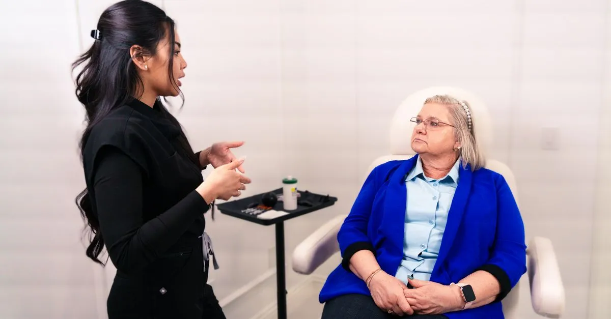 A med spa provider consulting with a client about elective aesthetic treatments in a modern treatment room.