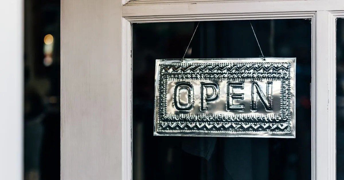An open sign hanging on a small shop door, the kind of local business that should be added to Google.