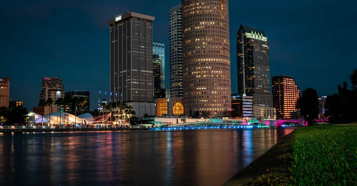 The downtown Tampa skyline lit up at night, reflected across the Hillsborough River, where local businesses compete for attention online.