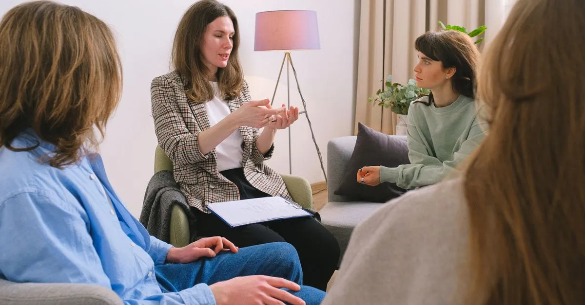 A counselor leading a supportive group therapy session at an addiction treatment center.