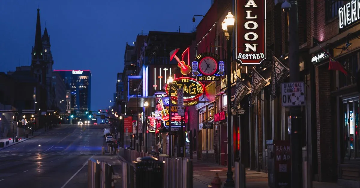 Neon honky-tonk signs glowing over Lower Broadway in downtown Nashville at dusk, the tourist-heavy blocks where near-me searches turn into walk-ins.