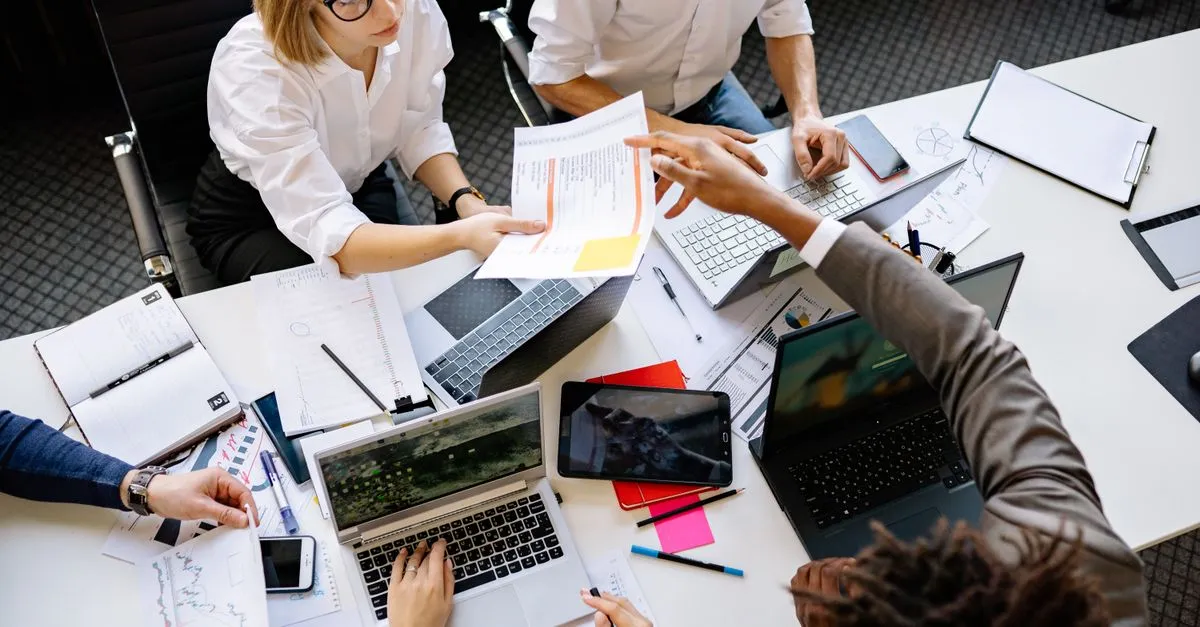 A small startup team collaborating around laptops in an open office, the kind of early-stage company SEO for startups helps get found.