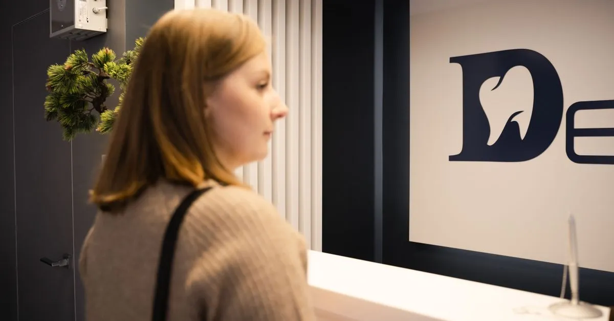 A patient at a dental office reception, the kind of practice websites for dentists are built to book.