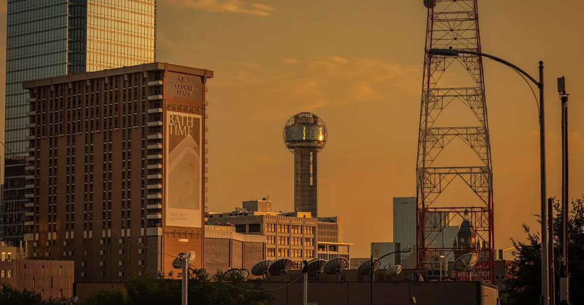Reunion Tower and a broadcast tower rising over downtown Dallas at golden hour, the sprawling metroplex market where the map pack is won.