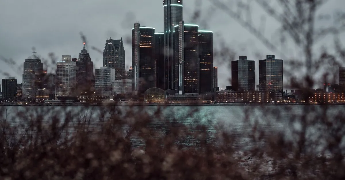 The Detroit skyline at dusk across the river, with the GM Renaissance Center towers lit up, where local businesses compete for attention online.