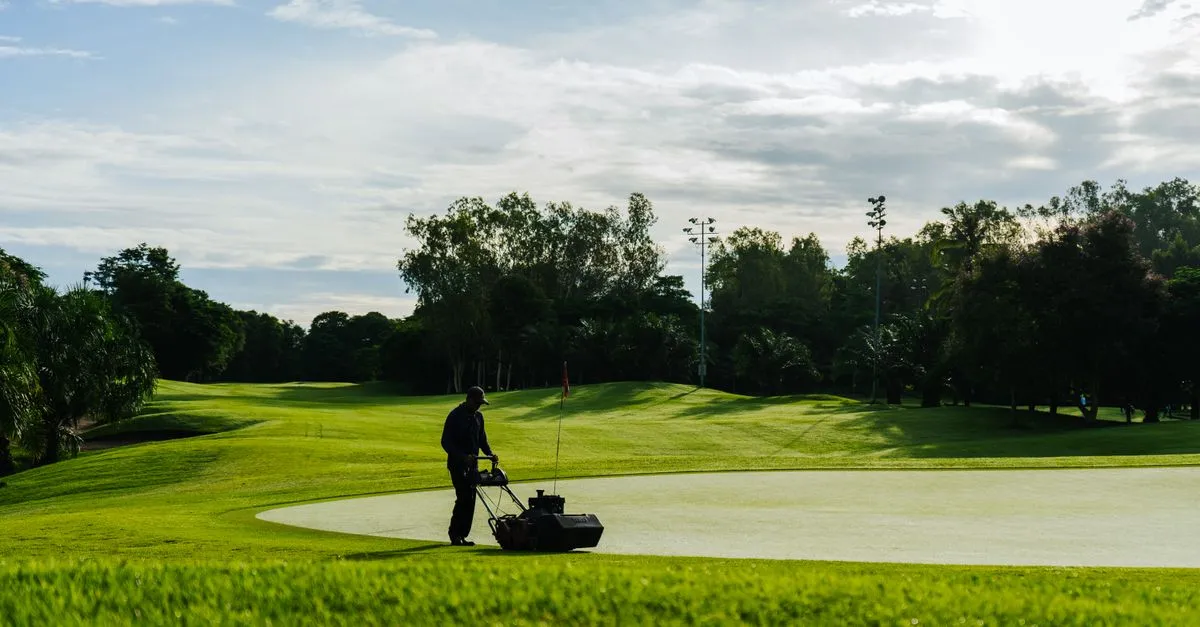 A landscaper mowing a wide stretch of green turf on a sunny day, the kind of crew local SEO for landscapers helps get found.