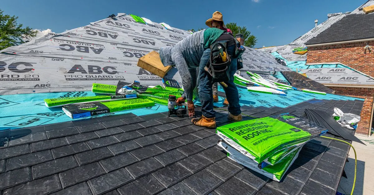 A roofer installing shingles on a residential roof, the kind of work a roofing company website is built to prove.
