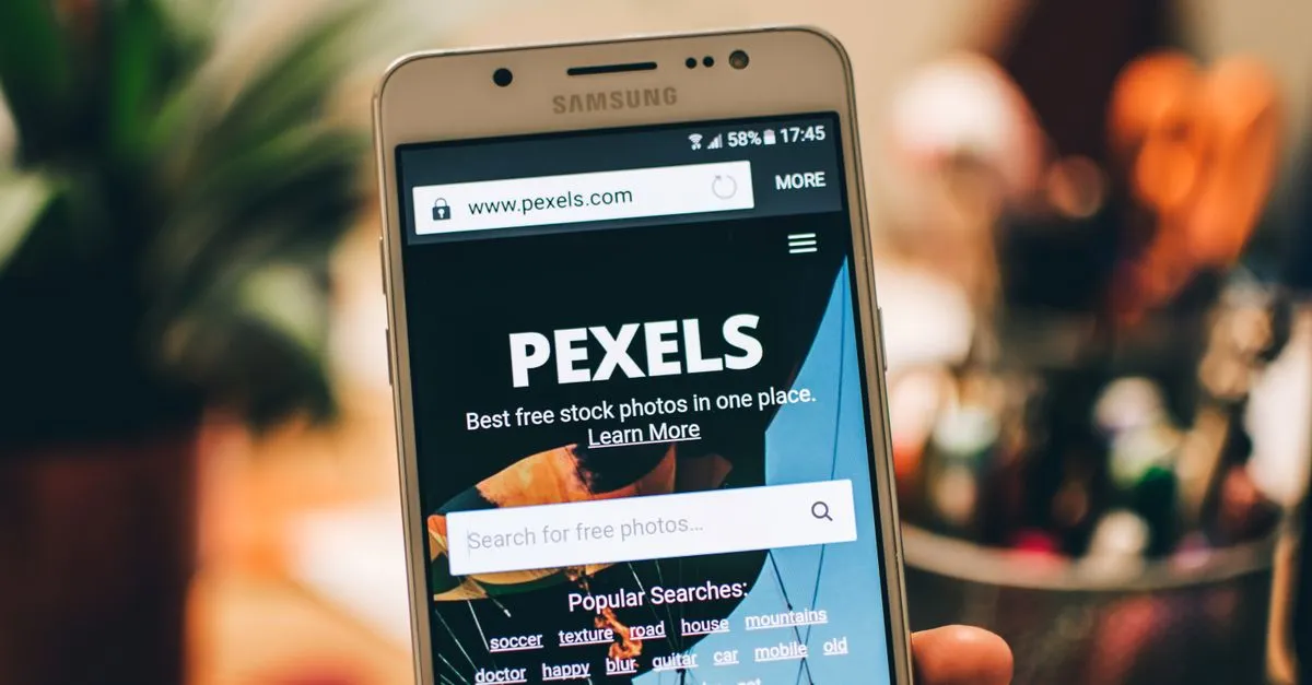 A smartphone held in a hand showing a website loaded in its mobile browser.