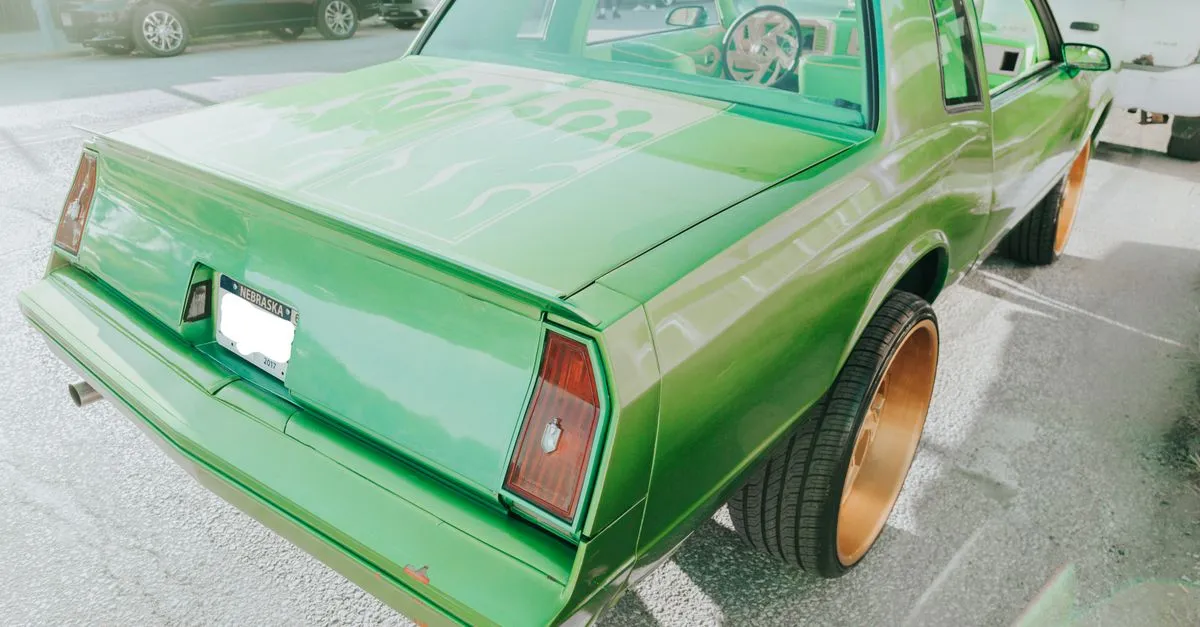 A bright green classic car with a Nebraska license plate parked on a sunny street in Omaha, Nebraska.