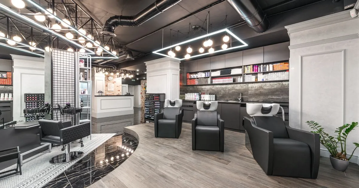A modern beauty salon interior with backwash chairs, mirrors, and product shelves ready for hair and color clients.