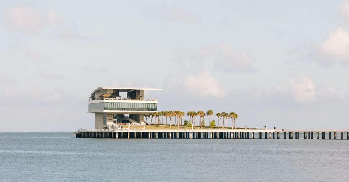 The inverted-pyramid St. Pete Pier building reaching out over the calm water of Tampa Bay under a bright Florida sky.