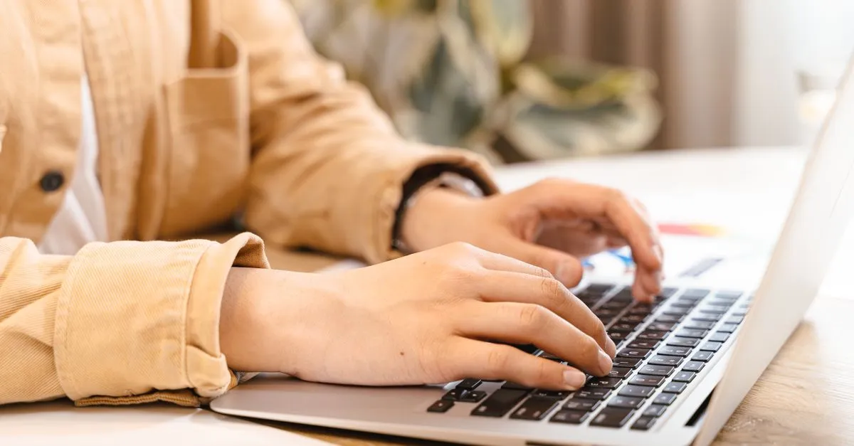Hands on a laptop writing content, the core of on-page SEO.
