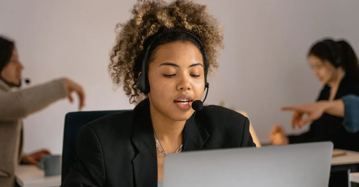 Business owner with a headset replying to customers on a laptop, standing in for responding to Google reviews.
