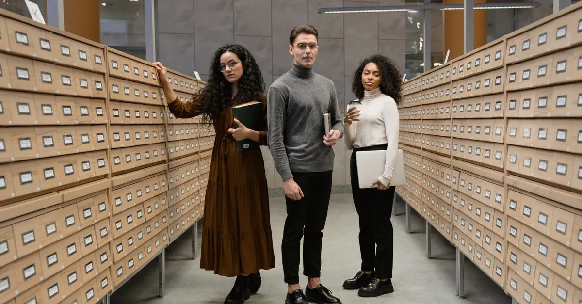 People standing between long rows of labeled archive drawers, like entries filed in a search index.