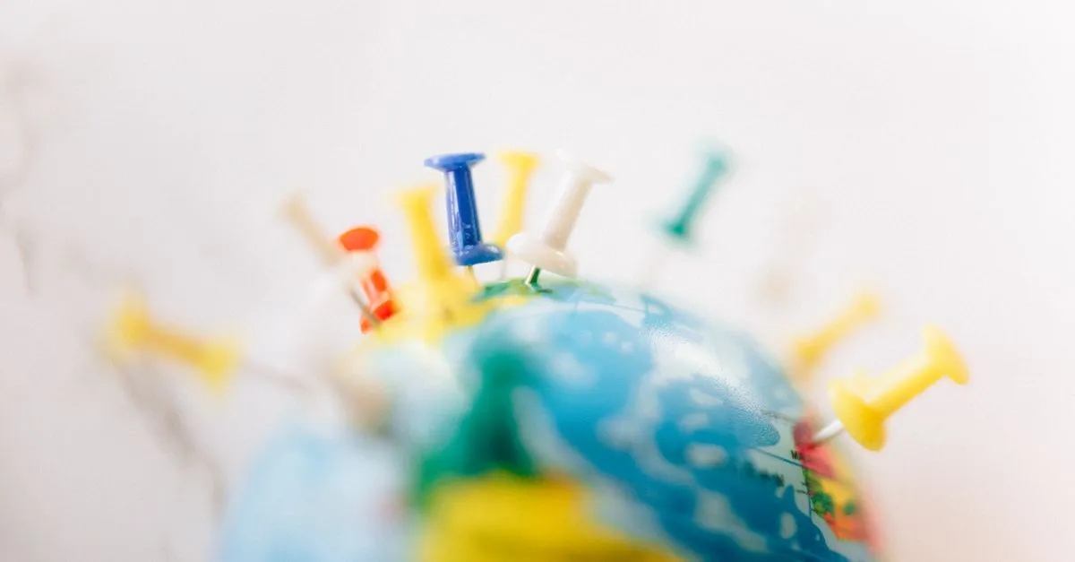 Globe marked with colorful location pins, representing near-me local search results.