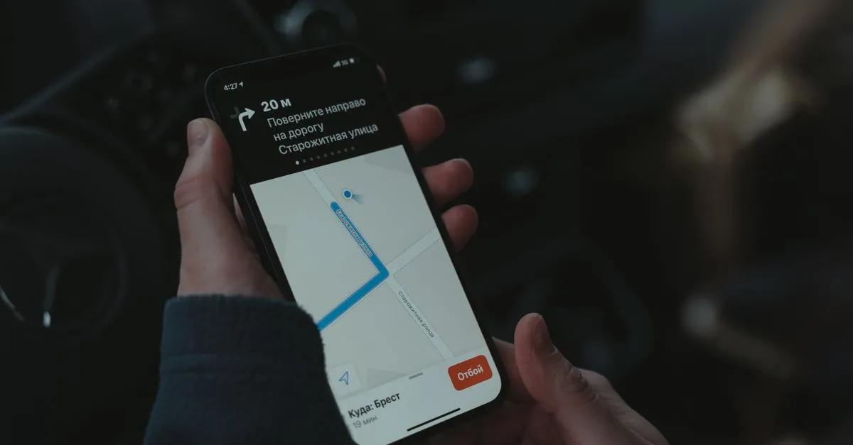 Hands holding a smartphone running turn-by-turn map navigation, the kind of local, on-the-go search voice assistants handle.
