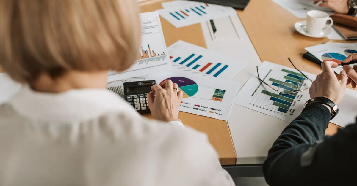 Doing paperwork at a desk, planning an SEO budget around a share of revenue.