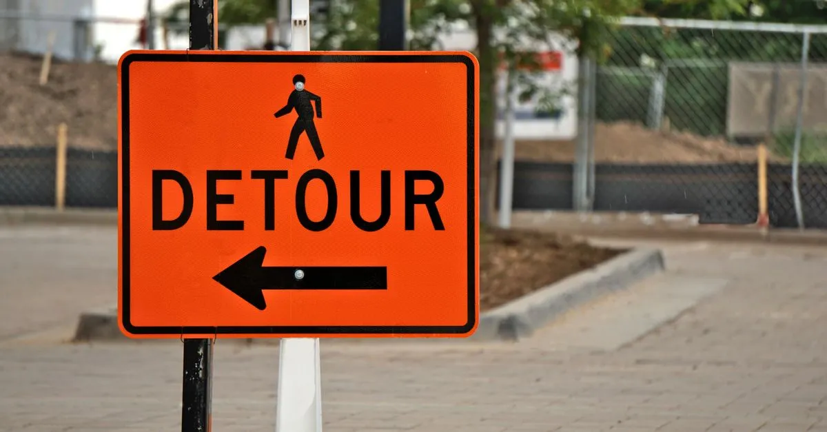 An orange detour sign directing traffic, like a 301 redirect guiding Google to new URLs.