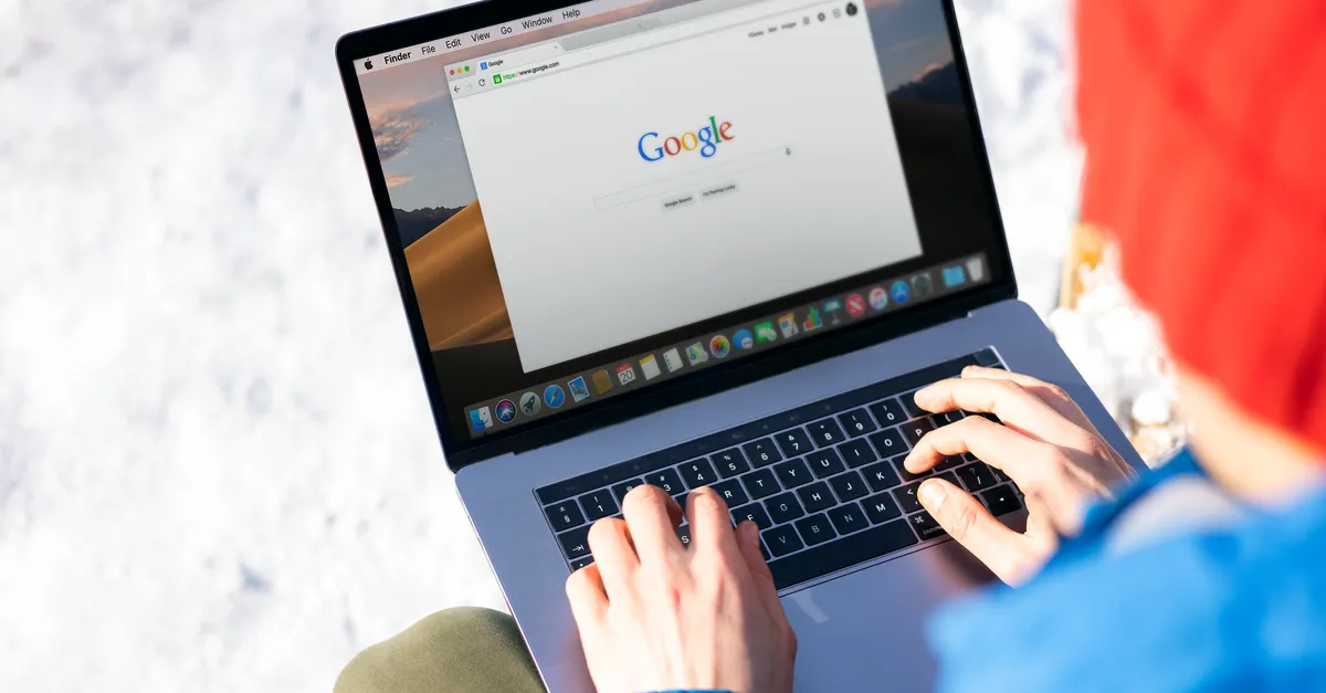 A person typing on a laptop with Google open in a web browser, the browser tab showing the page’s title.