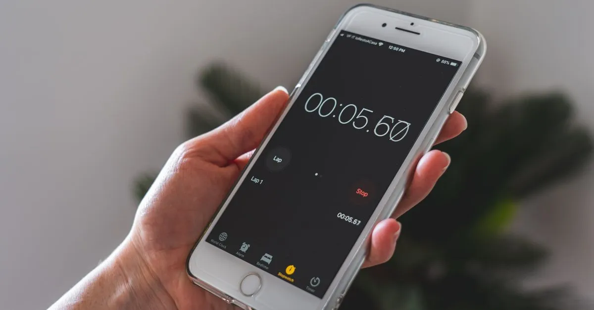 A hand holding a phone running a stopwatch, a reminder that homepage load speed is measured in seconds.