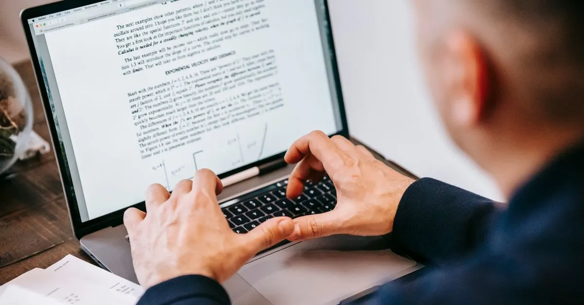 A person typing on a laptop, structuring content so AI can extract a clean answer.