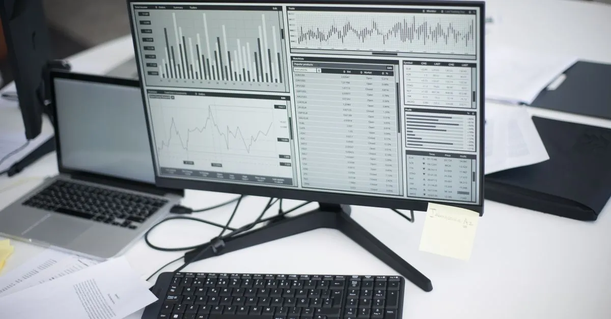 A desktop monitor displaying an analytics dashboard with charts, graphs, and data tables for tracking performance.