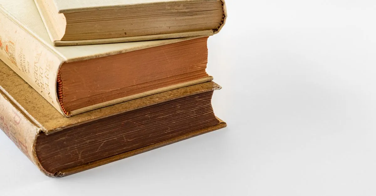 A small stack of three vintage hardbound books on a white surface, their layered page edges shown in different tones.